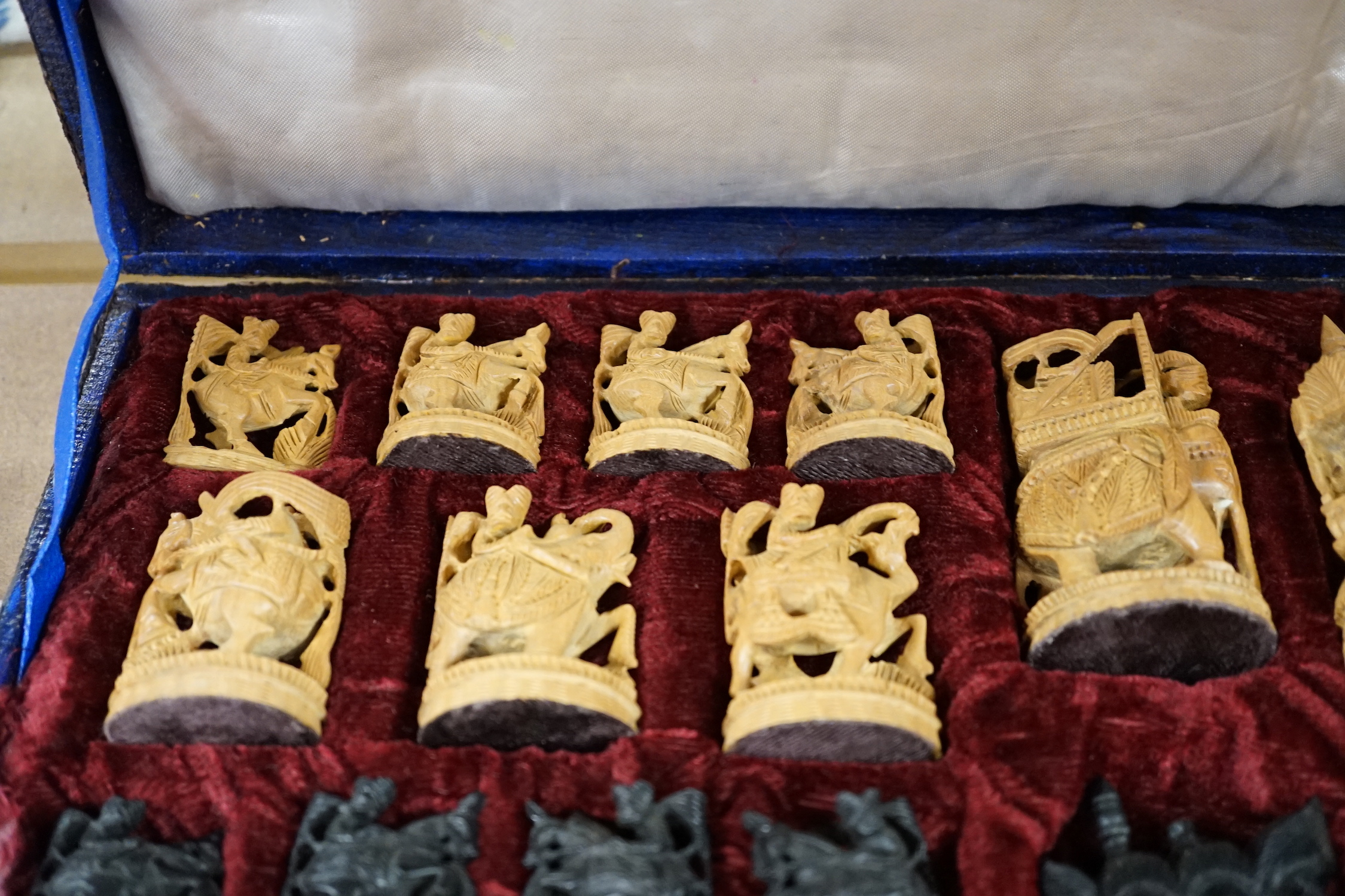 A cased Indian sandalwood and ebony figural chess set, case 50.5cm wide